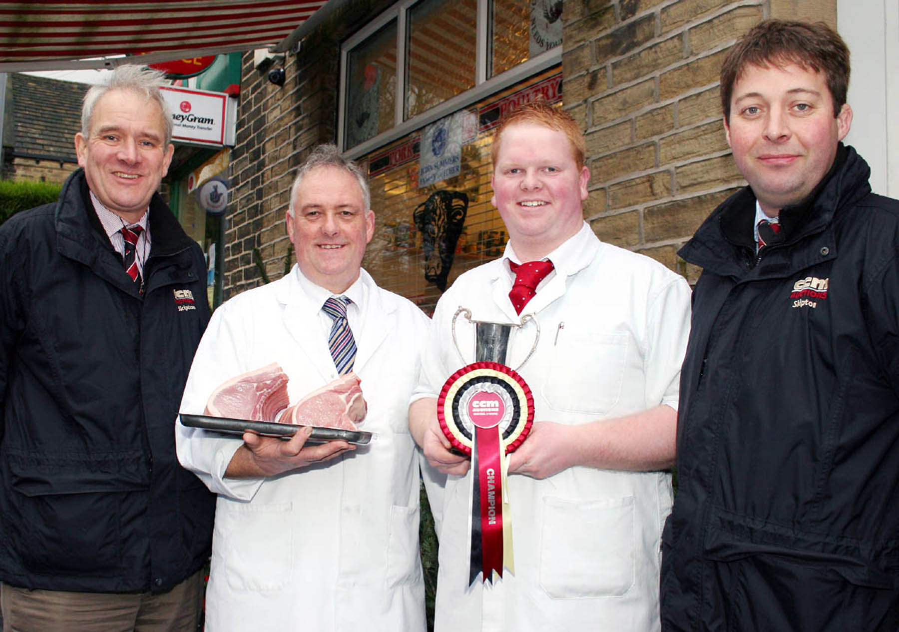 John Summers, second from left, and his butcher son Jack are pictured outside their Clayton shop with choice cuts of their championship-winning Christmas pork, joined by Skipton Auction Mart’s general manager Jeremy Eaton, left, and livestock sales manager Ted Ogden. 