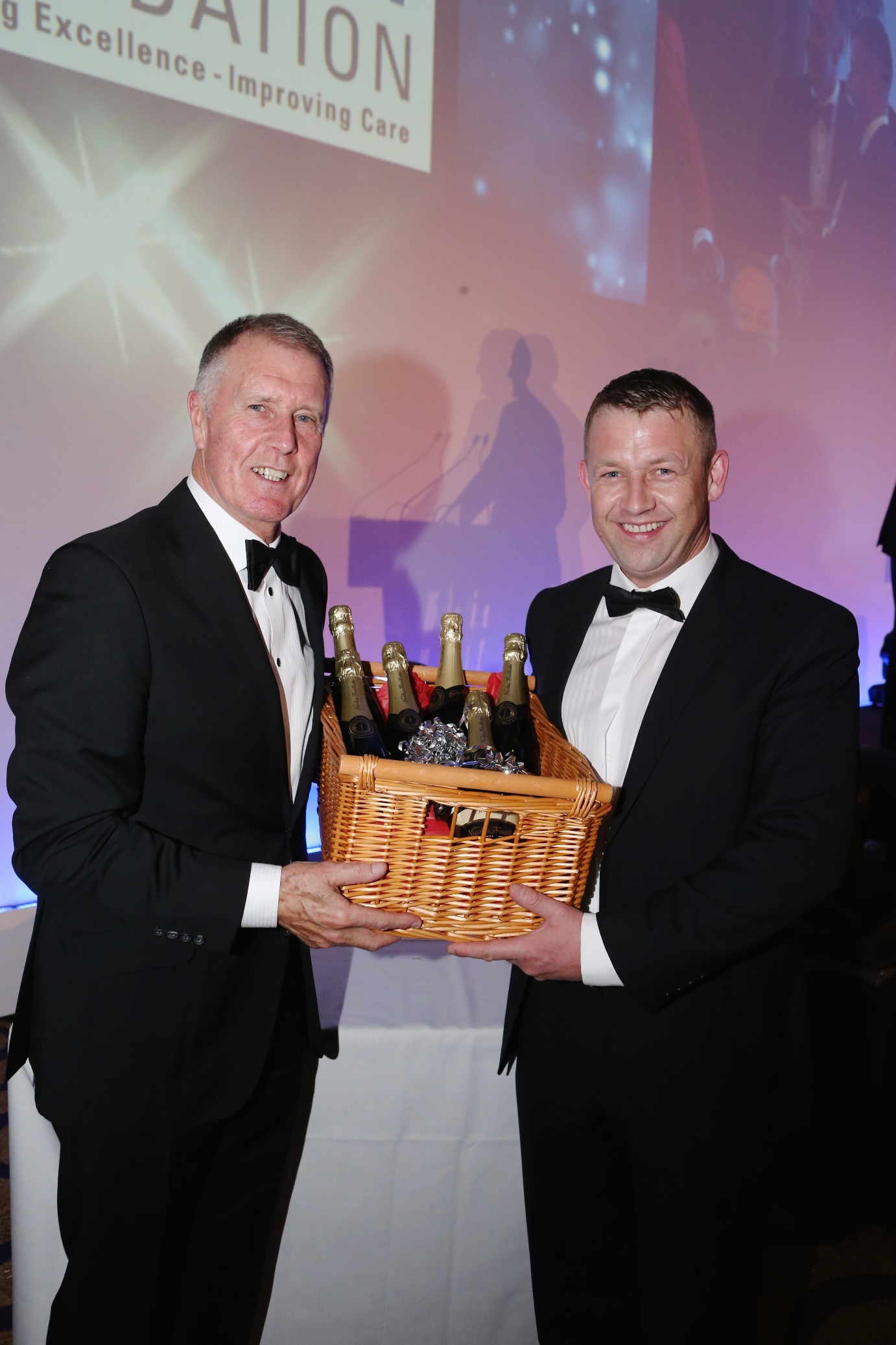 John Davidson of Davidson Retail Butchers collecting his champagne raffle prize from Geoff Hurst.