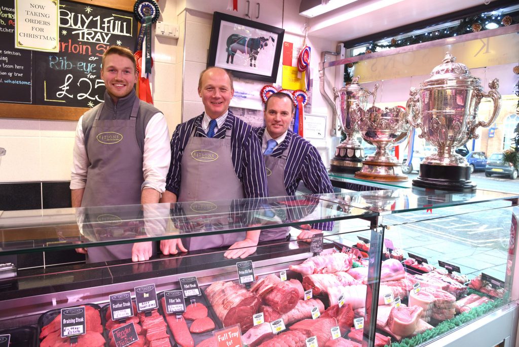 Oliver and Anthony Kitson with Martin Calvert in the Northallerton butchers shop with the three winter Fair trophies.