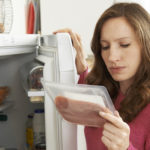 Concerned Woman Looking At Pre Packaged Meat