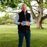 Rick Buckle, managing director Farms - Pork Division at Cranswick Plc. He stands in a field, a tree visible in the background, and he holds a packet of pork from Lidl.