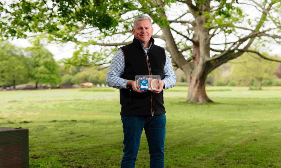 Rick Buckle, managing director Farms - Pork Division at Cranswick Plc. He stands in a field, a tree visible in the background, and he holds a packet of pork from Lidl.